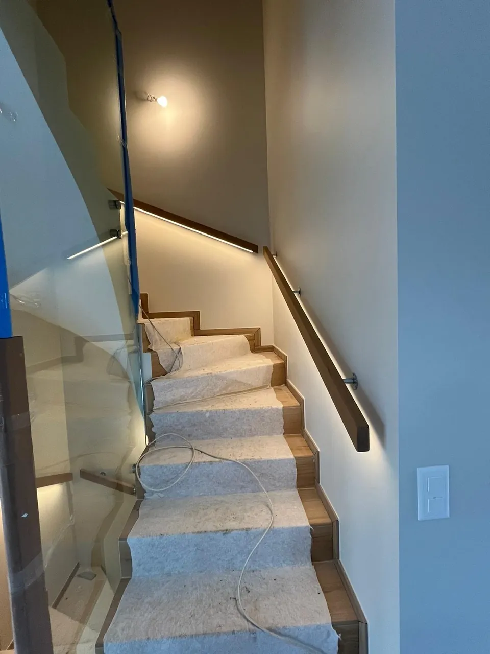 Wooden staircase with glass balustrade and handrail