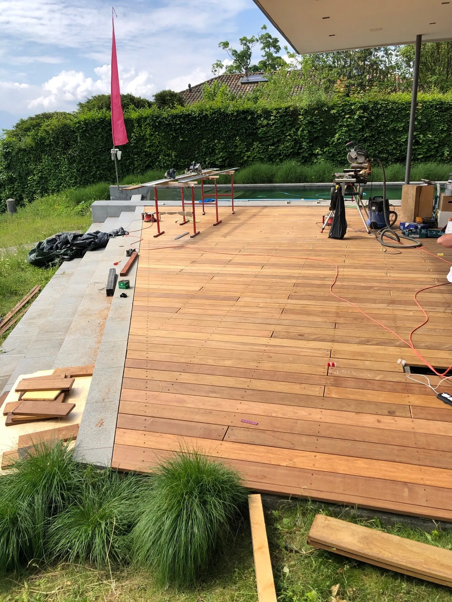 Terrasse en bois en cours de pose au bord d’une piscine