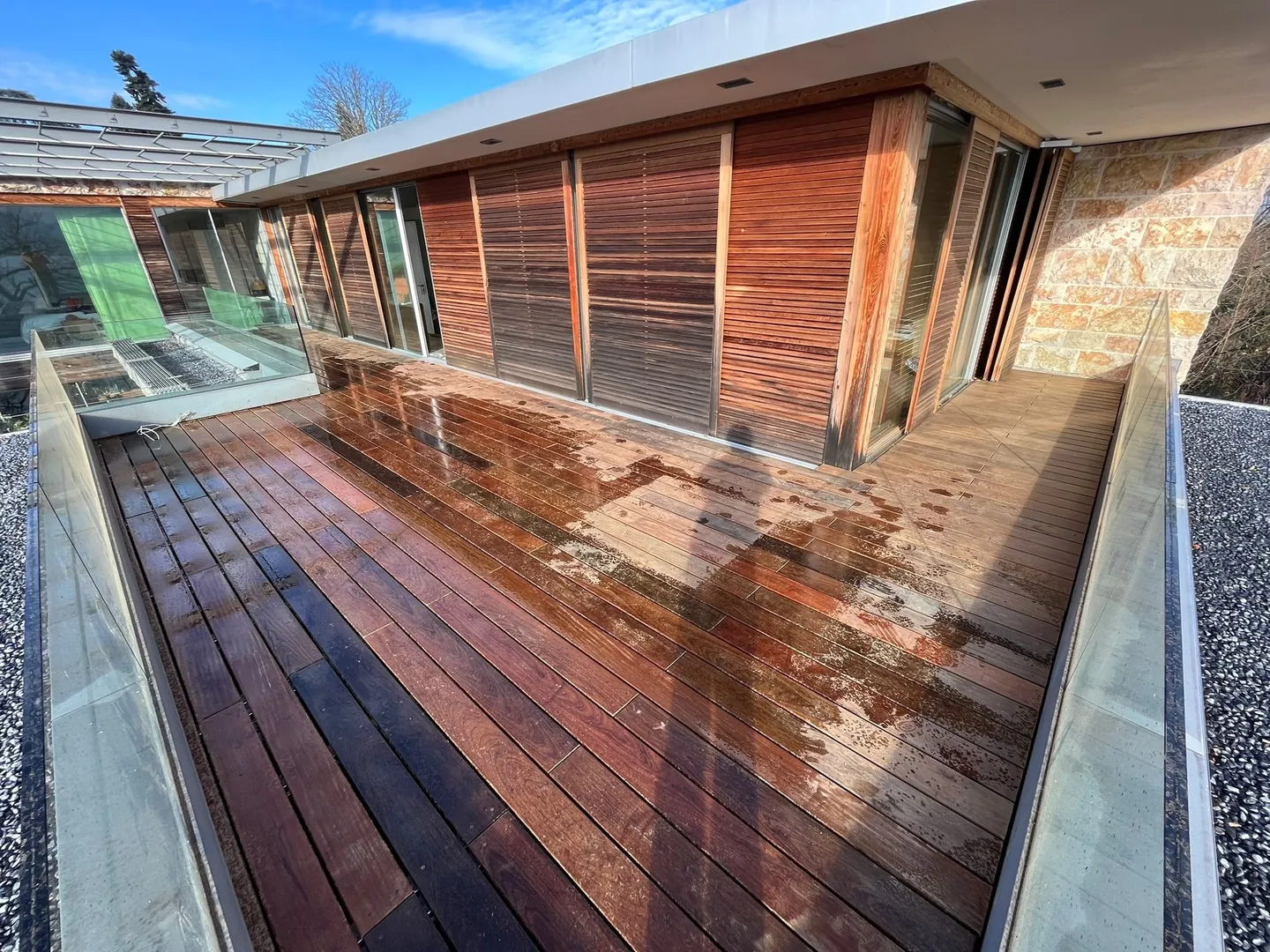 Terrasse en bois exotique devant une villa avec bardage bois