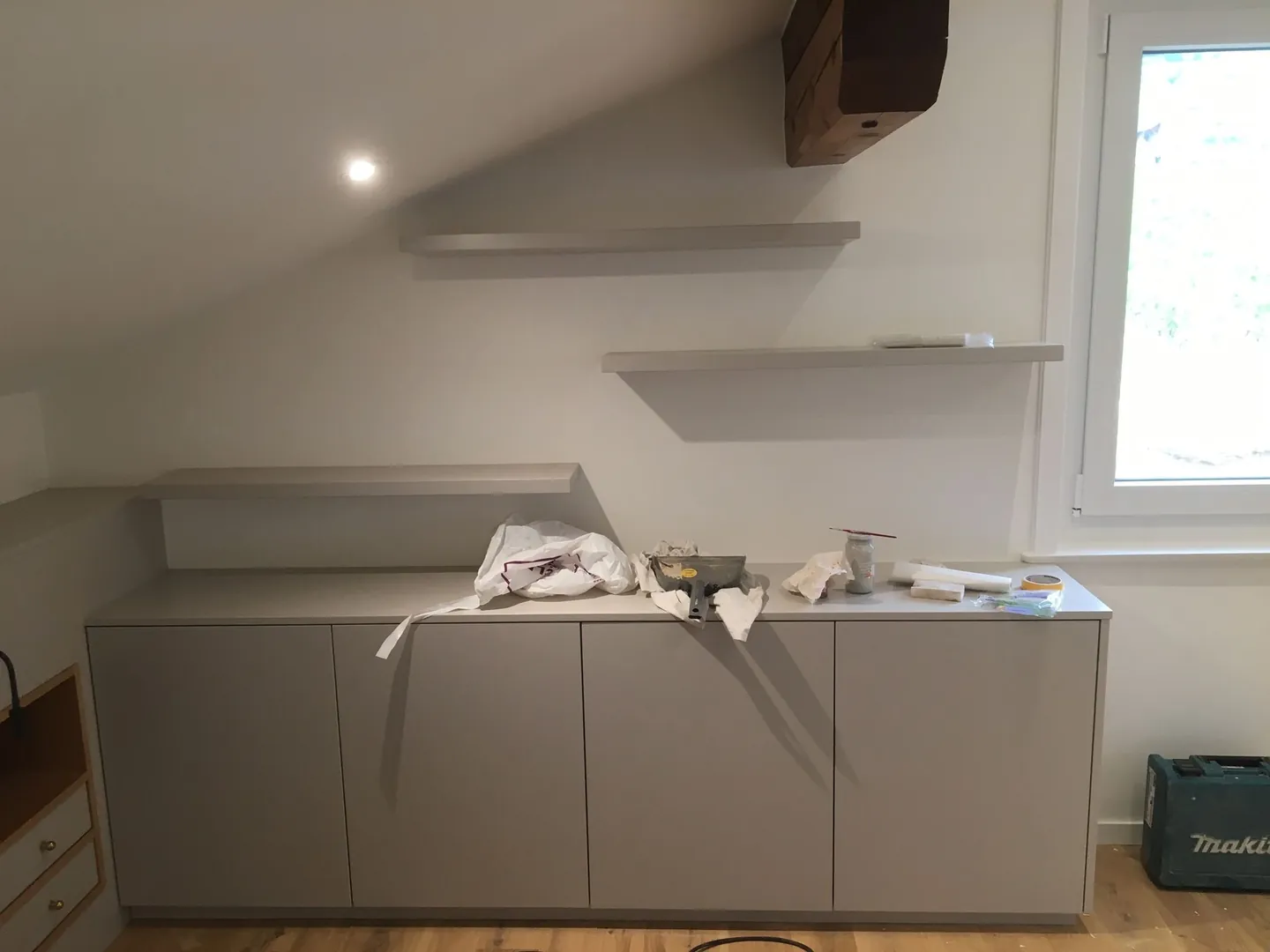 Meuble bas sur-mesure en cours de pose sous une fenêtre